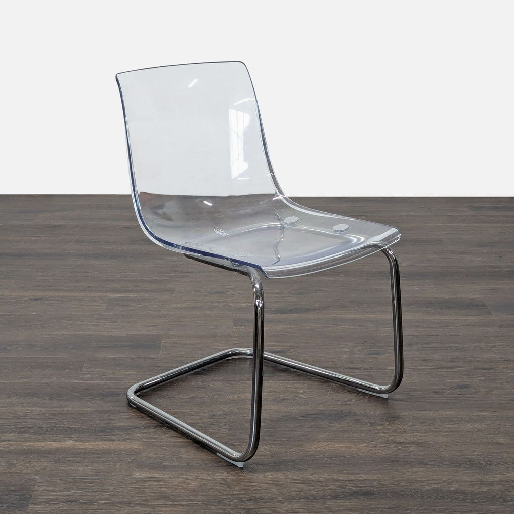 Simple dining chair by Ikea, featuring a plastic body and shiny chrome metal legs.  