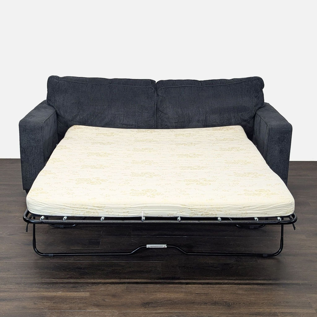 Ashley Furniture sleeper sofa in neutral gray, featuring a sturdy build and spacious seating that folds into a bed.