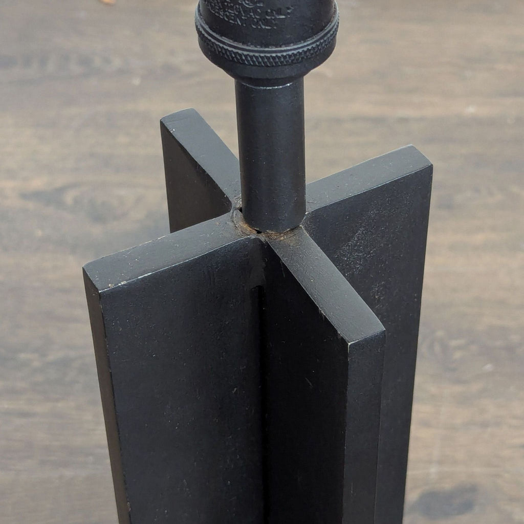 Contemporary lamp with a minimal white shade and unique cross design base, giving off soft, warm light.  