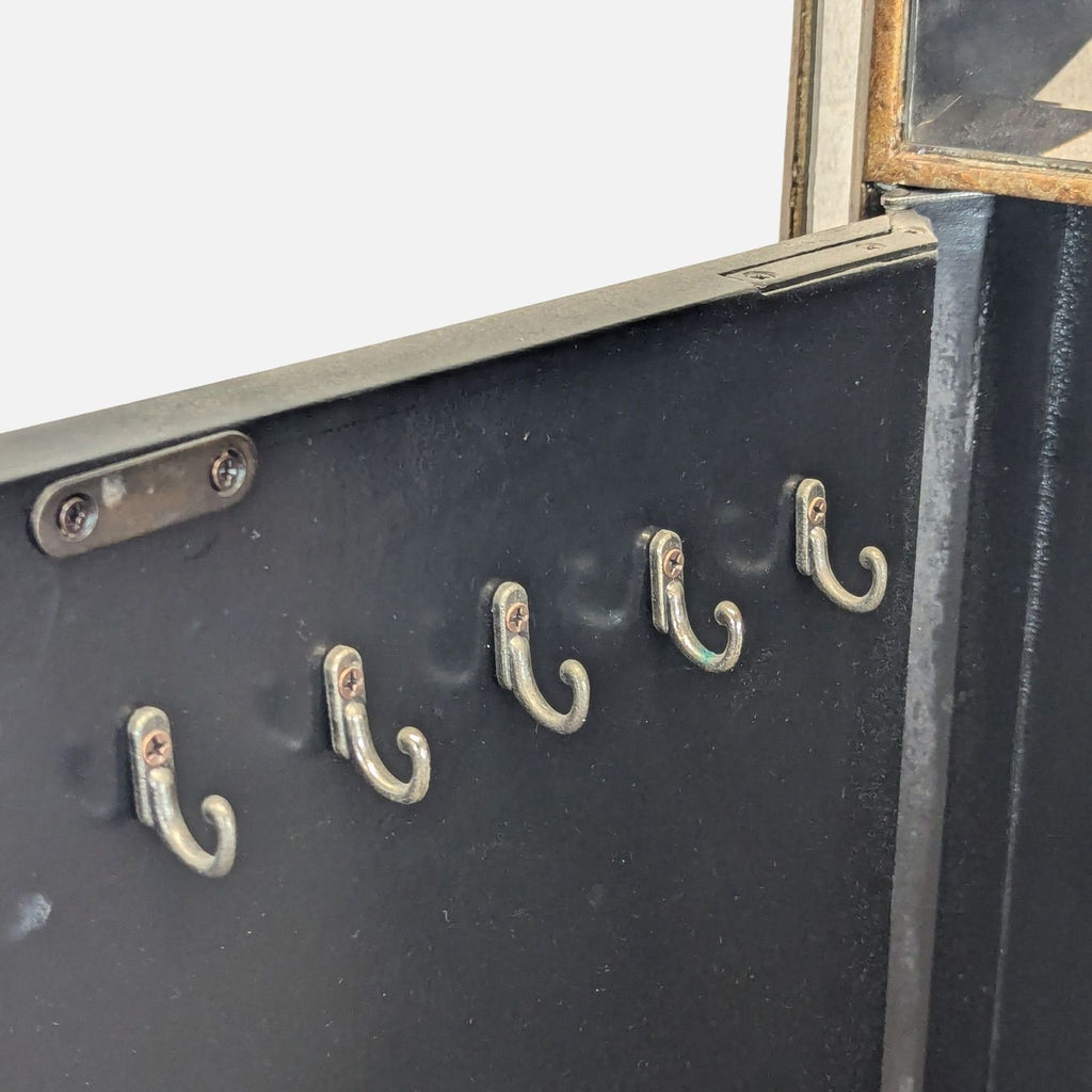 3. Close-up of interior side door of the dresser with five small metal hooks for hanging necklaces or bracelets.