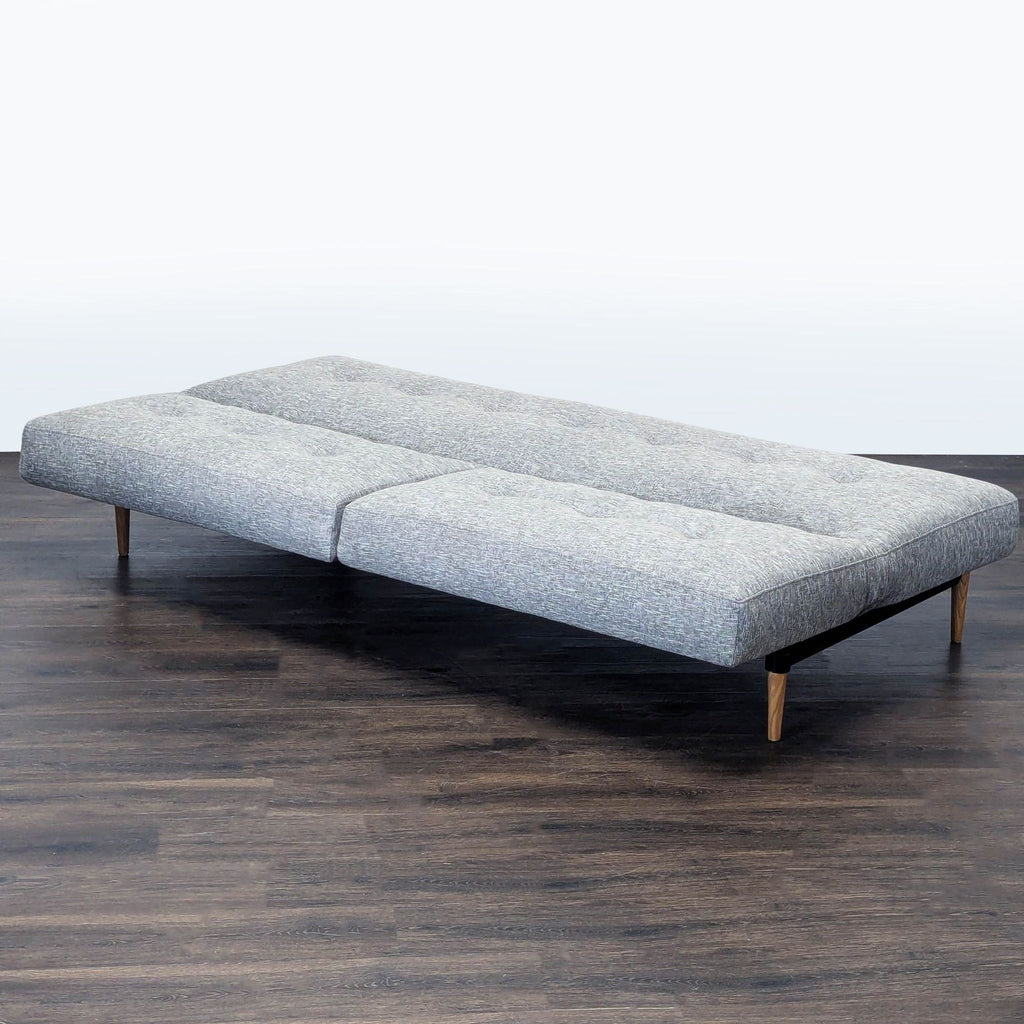 2. West Elm gray sleeper sofa converts to a flat bed, ideal for guests or small spaces, elegant tufted design.