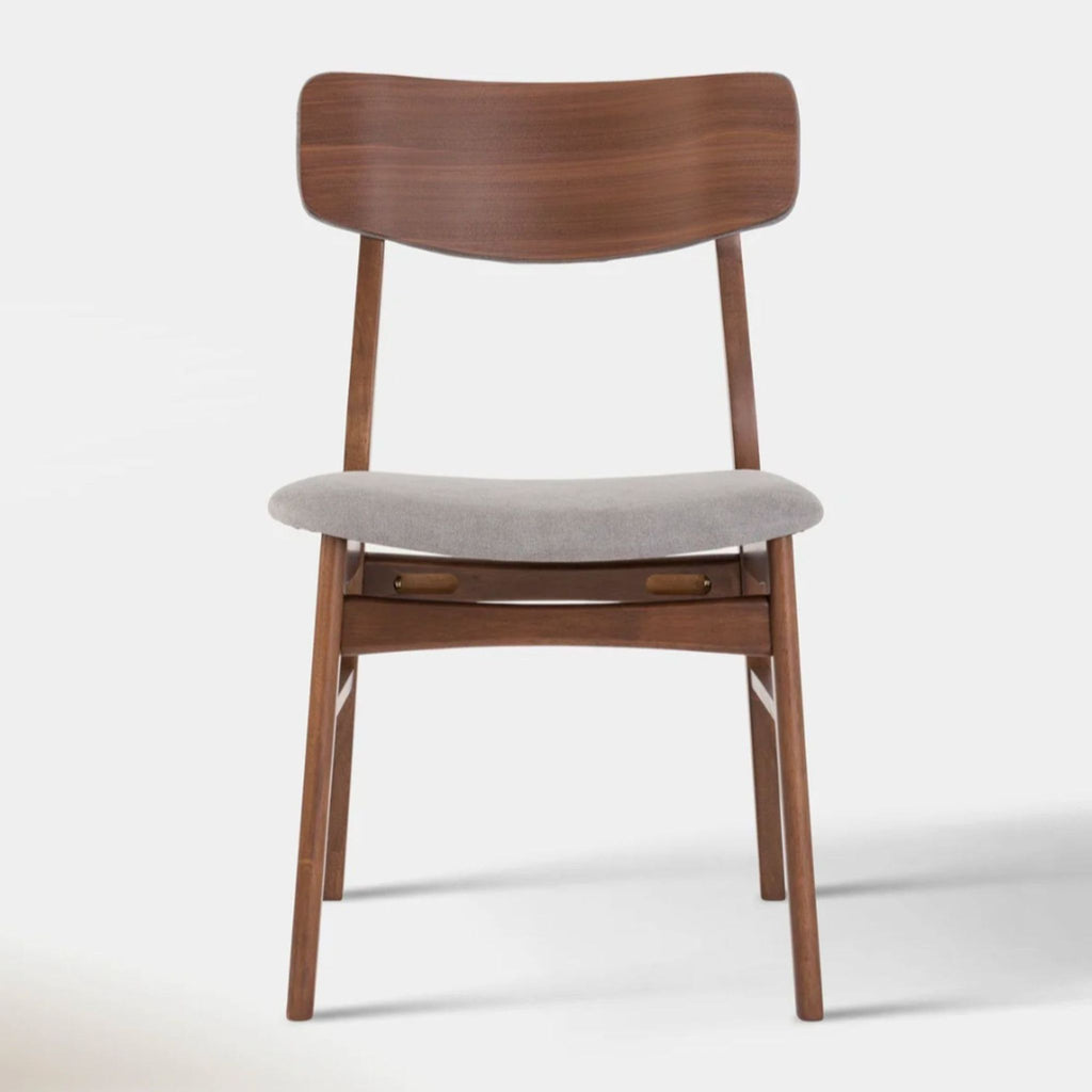 Front view of a Hoft Home dining chair with smoke and walnut finishes, featuring a curved wooden backrest.