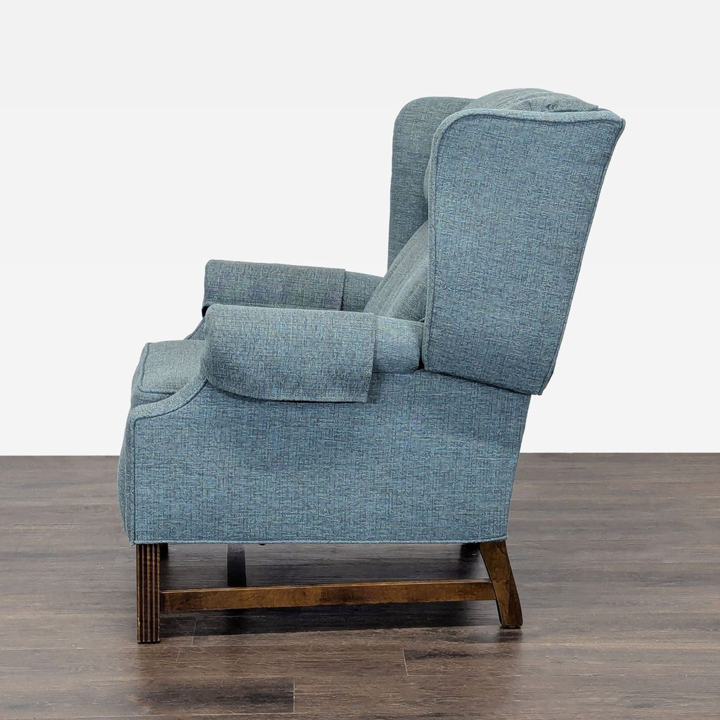 Comfortable blue recliner with plush seating and classic wooden legs, ideal for any living room lounge space.