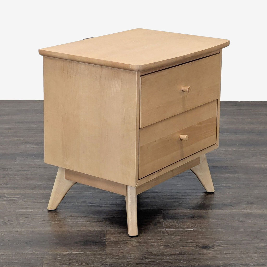 3. Angled view of a two-drawer, light wood end table with simple knobs and splayed legs.