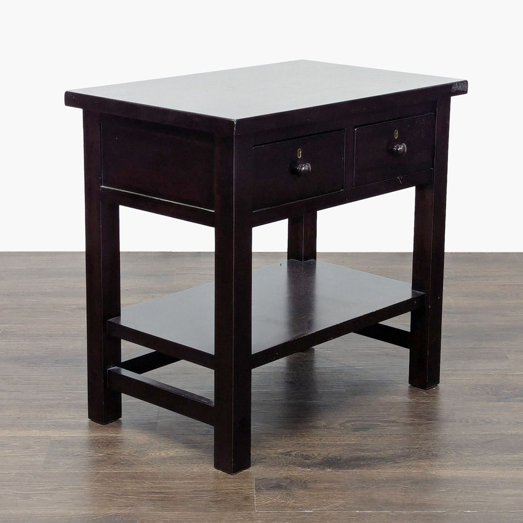 3. Angled view of a Pottery Barn end table in dark finish, with two drawers and a shelf below for storage.