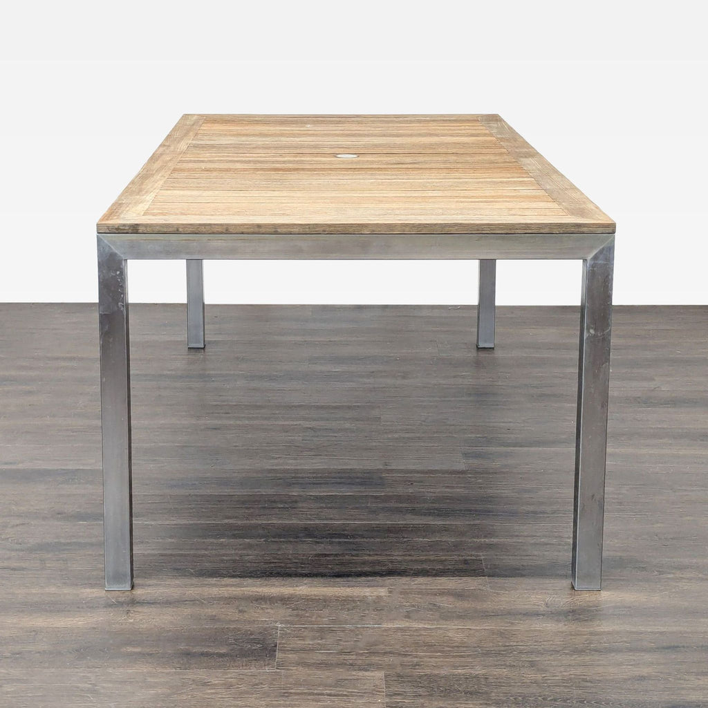 2. End view of a Kingsley-Bate rectangular table, featuring a teak slat top and stainless steel legs.  