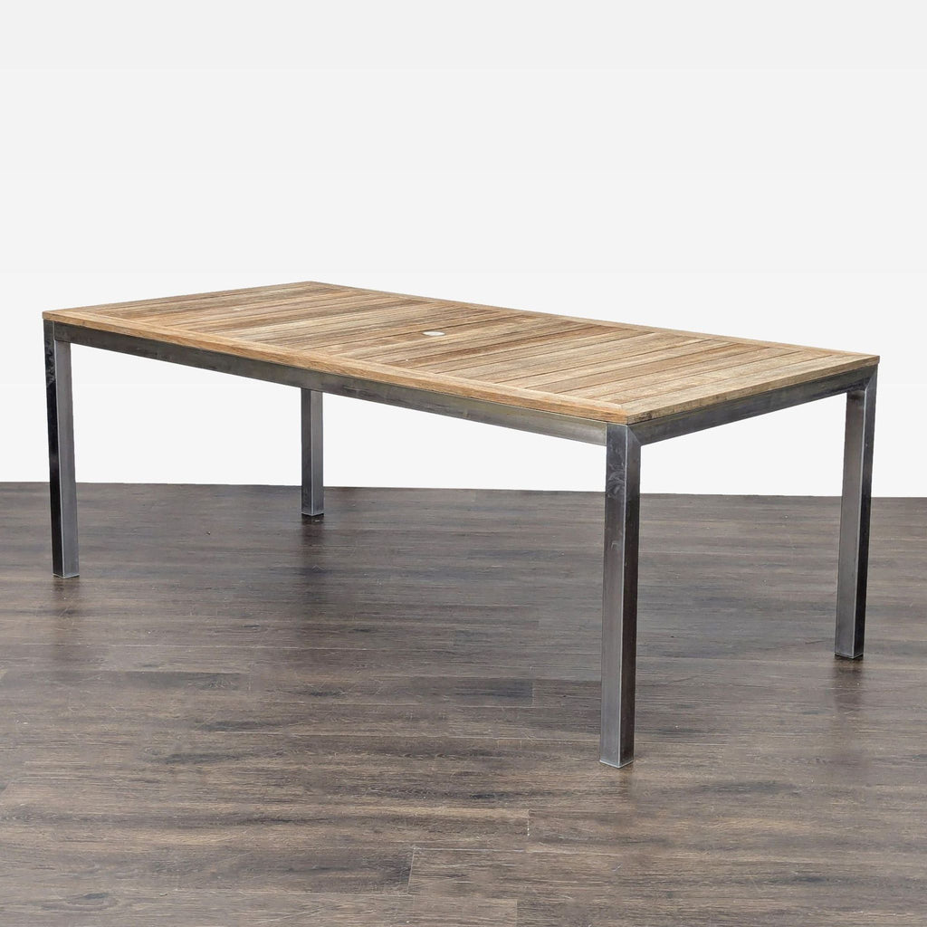 3. Angled view of a Kingsley-Bate table with a teak slatted top and metal frame, on a dark wood floor.