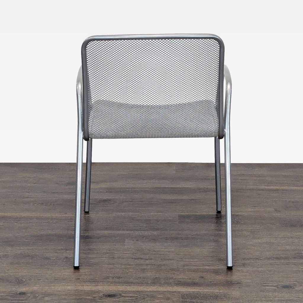 Stylish silver mesh chair with armrests by Room and Board, suitable for homes, offices, or patios.