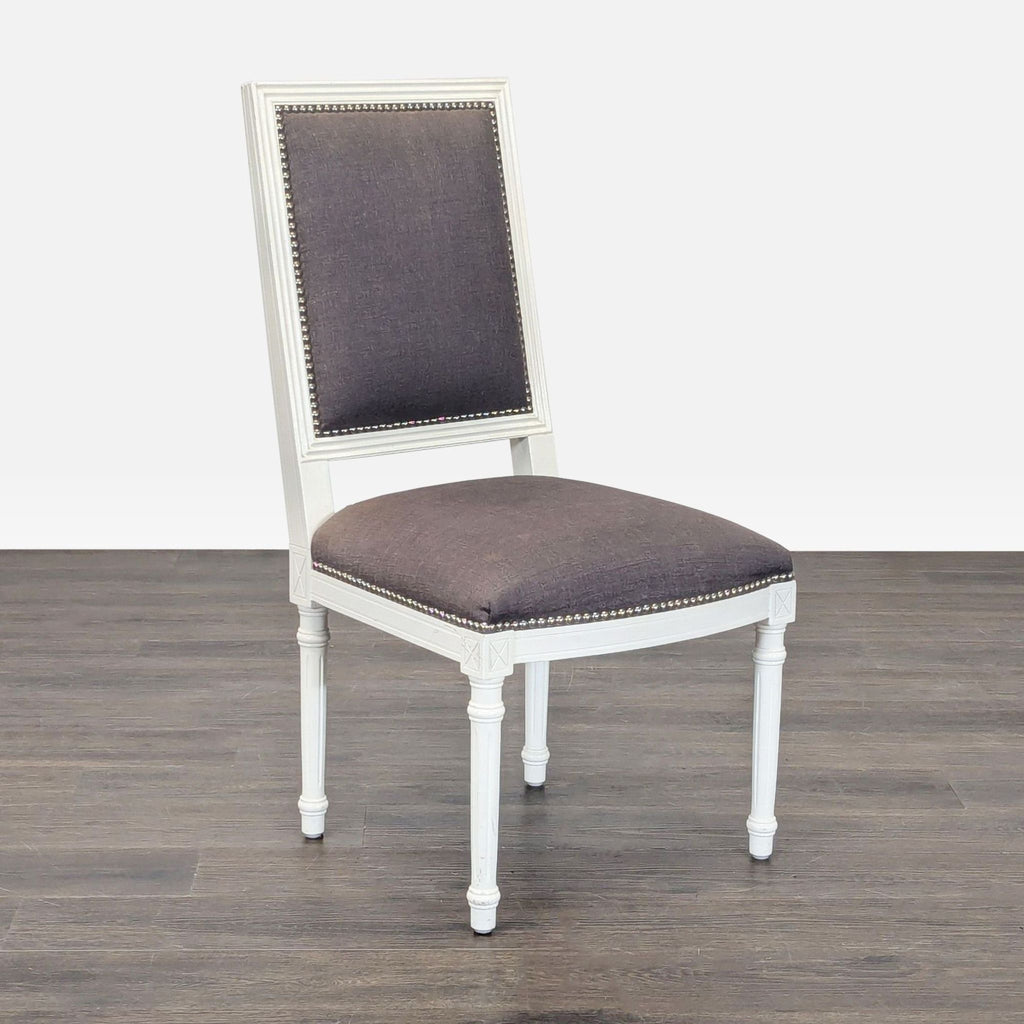 Jonathan Adler dining chair featuring X-back wood design, upholstered linen seat, and nailhead accents.