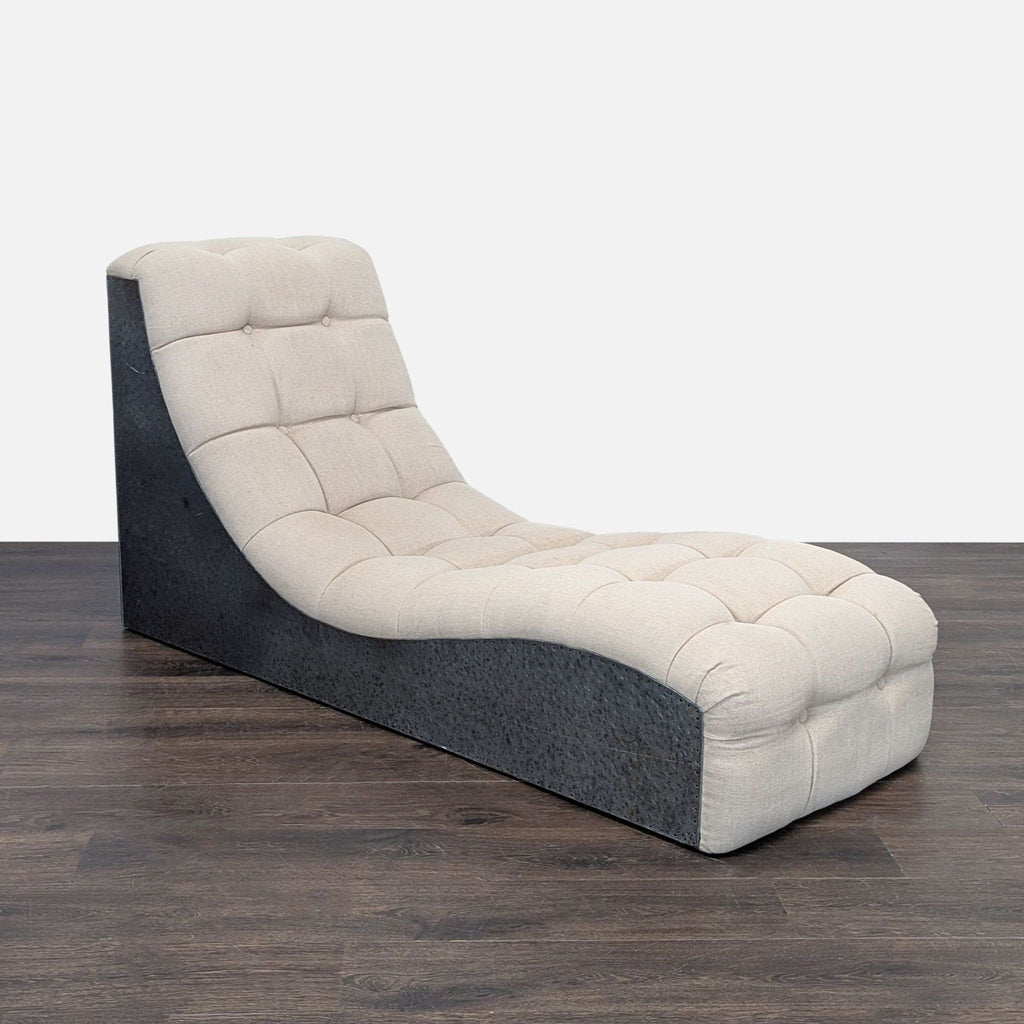 2. Angled side view of a beige tufted lounge chair, featuring a black textured base and ergonomic curve.