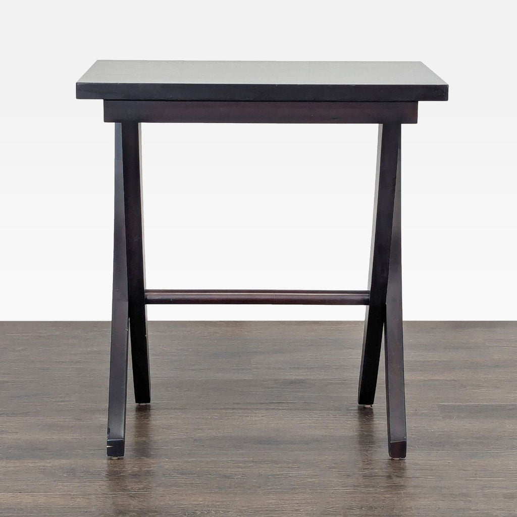 3. Rectangular dark wood end table with unique angular legs, viewed from the front on a wooden floor.