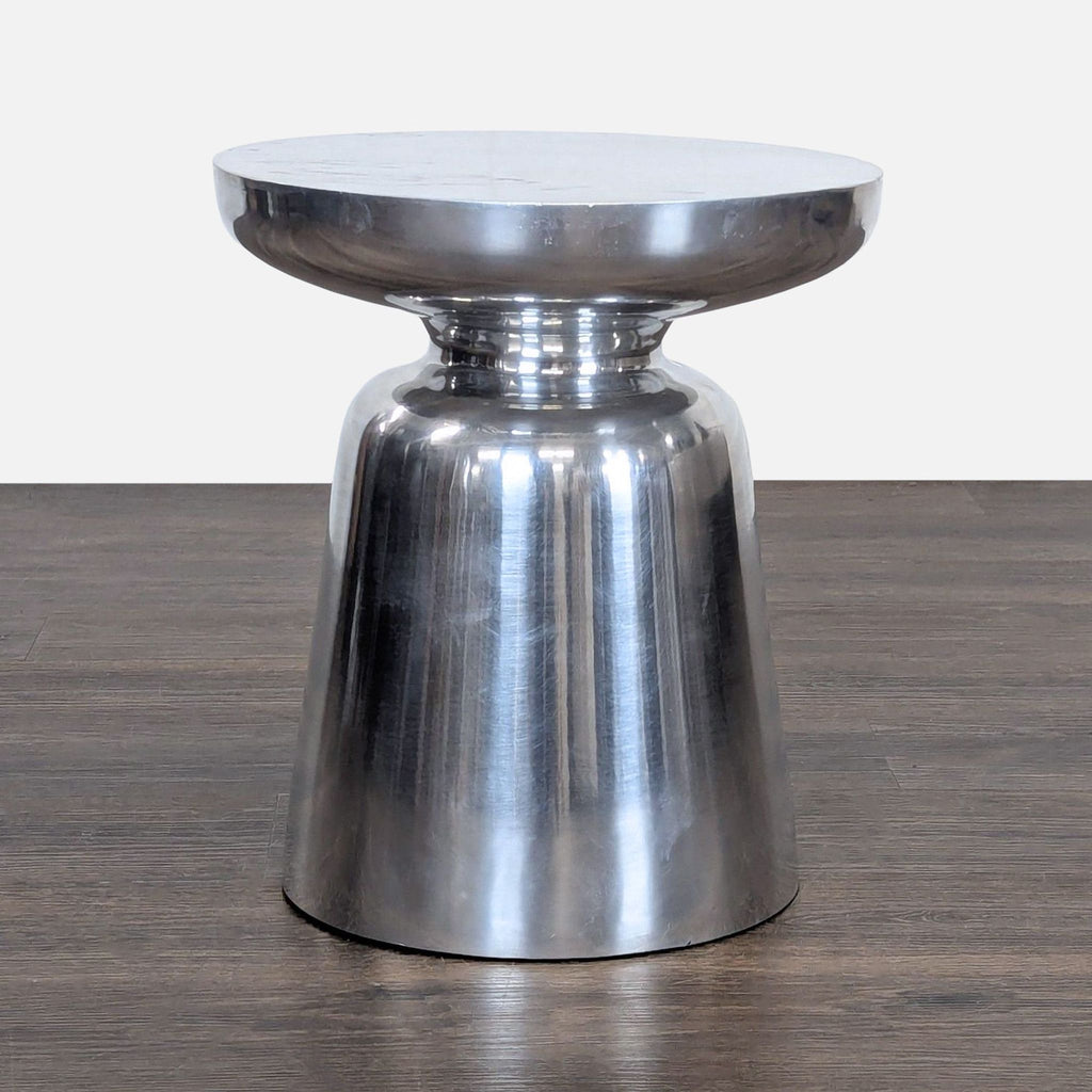 1. Modern metallic side table with a rounded top and flared base, displayed on a dark wood floor.