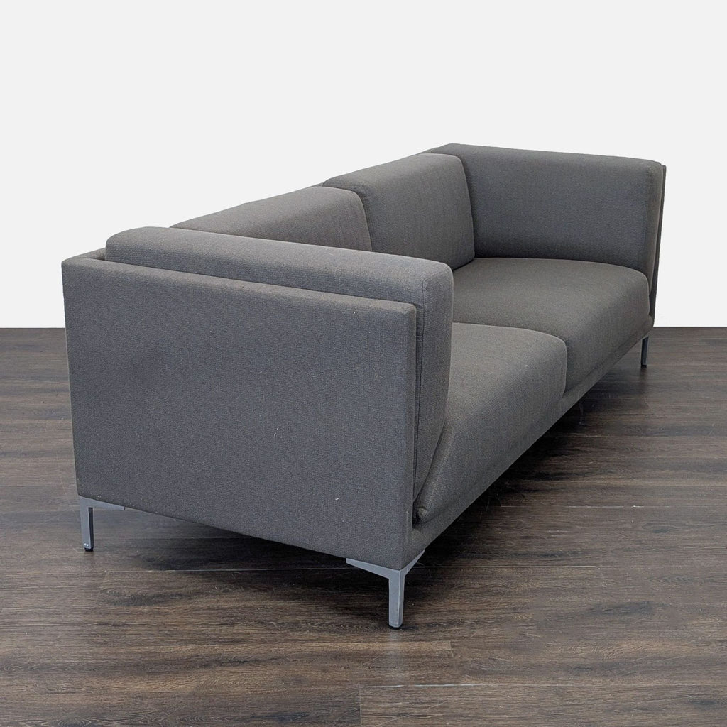 Modern dark gray loveseat by CB2 featuring clean lines, plush seating, and metal legs for a sleek, compact look.