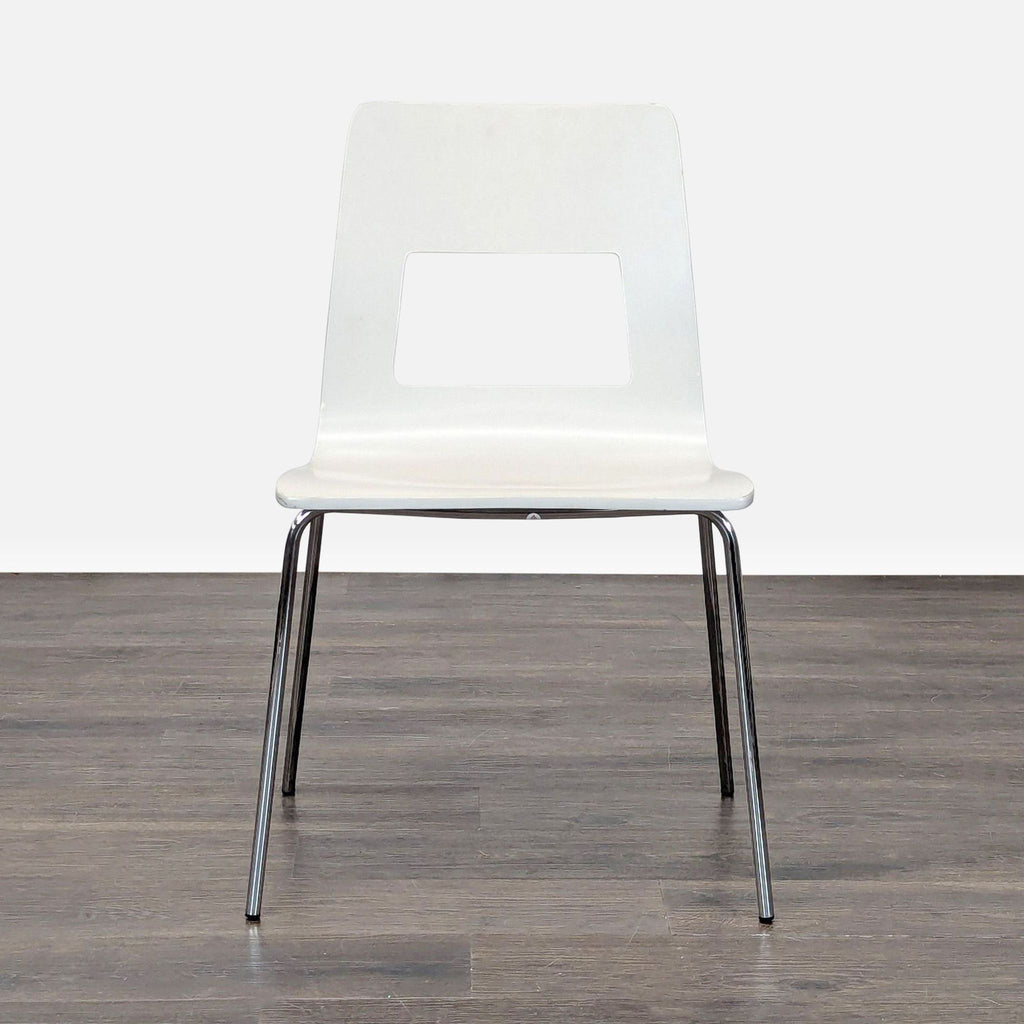 1. White modern dining chair with a rectangular cutout back and chrome legs, positioned on wood flooring.