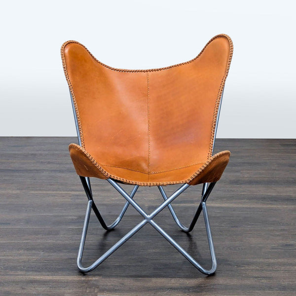 Classic butterfly lounge chair with brown leather seat and black metal frame, suited for modern interiors.