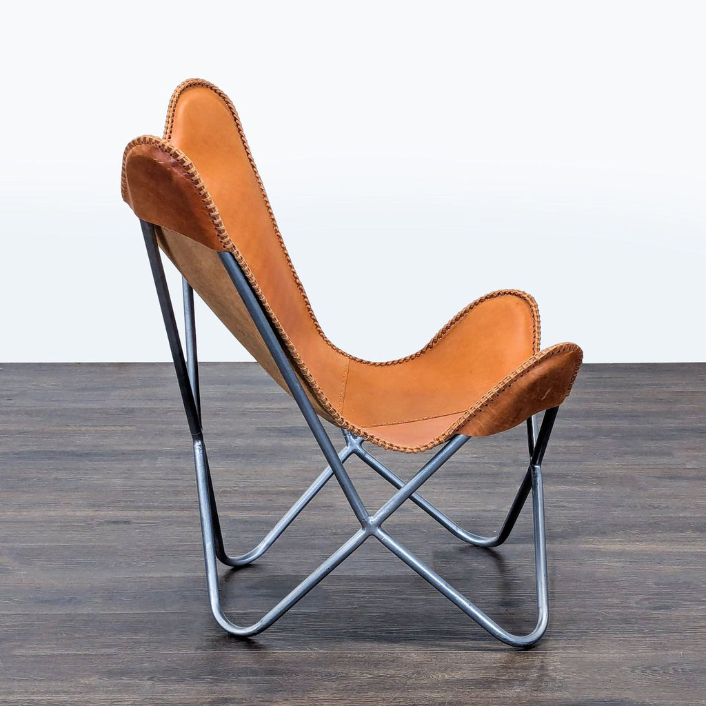 Brown leather butterfly chair with sleek black frame, perfect accent for living rooms or cozy lounge spaces.