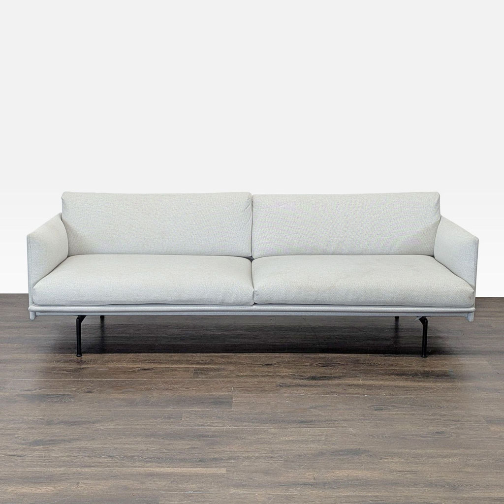 Muuto 3-seat sofa with light fabric, slim black legs, and modern, minimalist design.