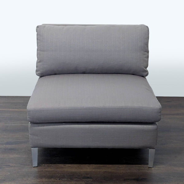CB2 lounge chair with gray fabric cushions and metal legs, offering a modern and comfortable seating option.