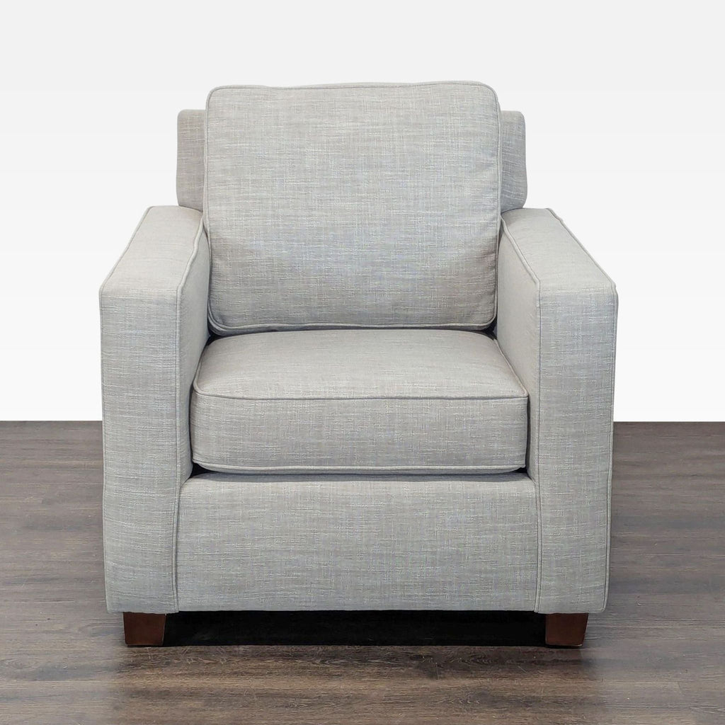 West Elm lounge armchair with modern linen fabric, cushioned seat, and wooden legs for stylish comfort.