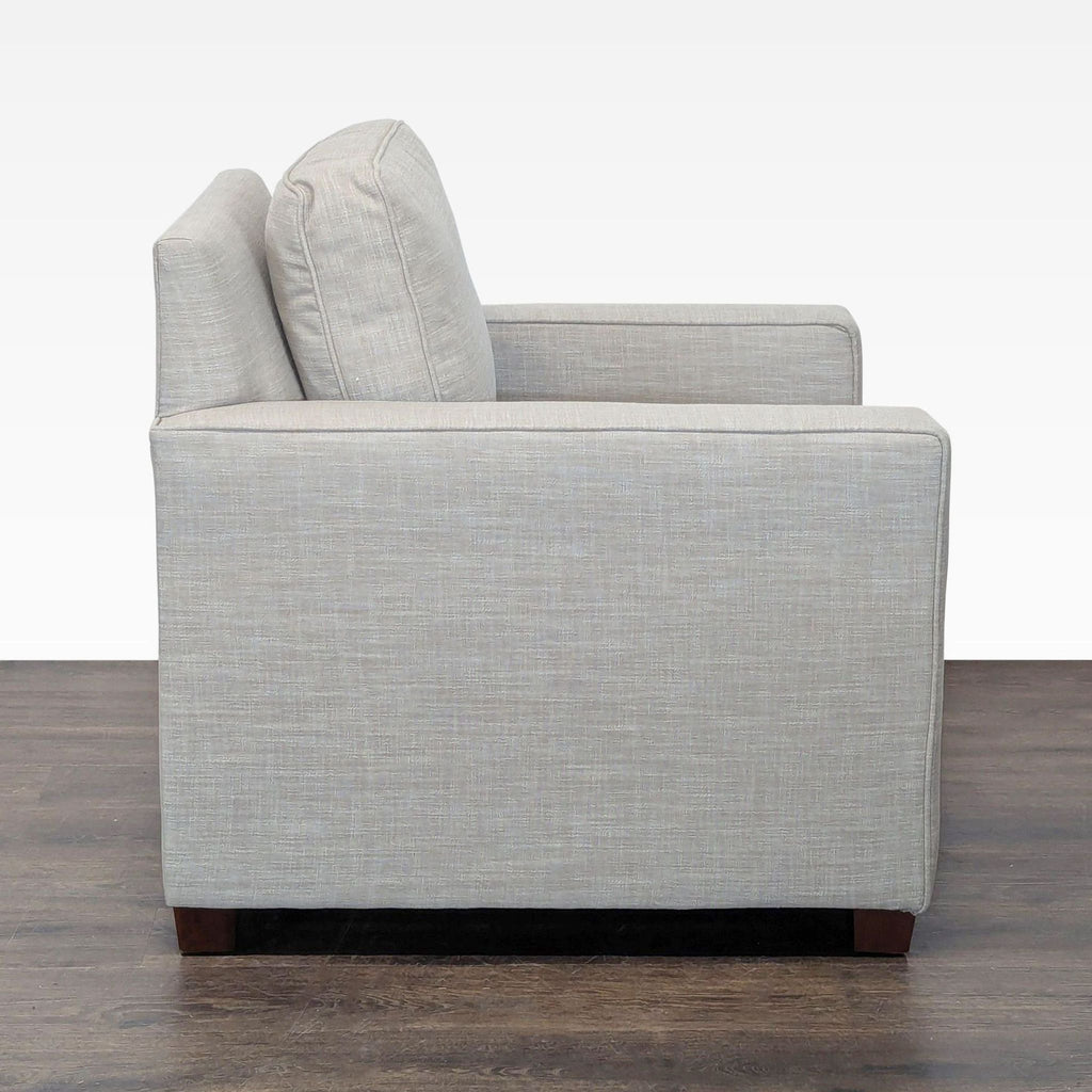 Contemporary West Elm armchair with sturdy wood legs, sleek linen fabric, and a spacious, comfy design.