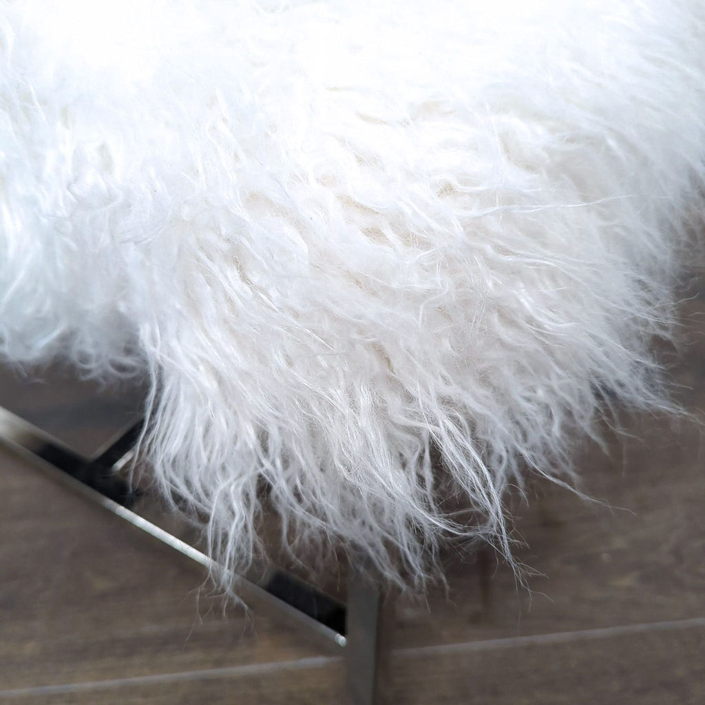 3. Detailed shot of a soft, long-haired white faux fur cushion on a metal-framed ottoman.