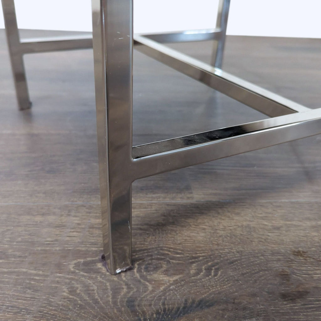 2. Close-up view of shiny chrome metal legs with crossbar support from a contemporary stool.