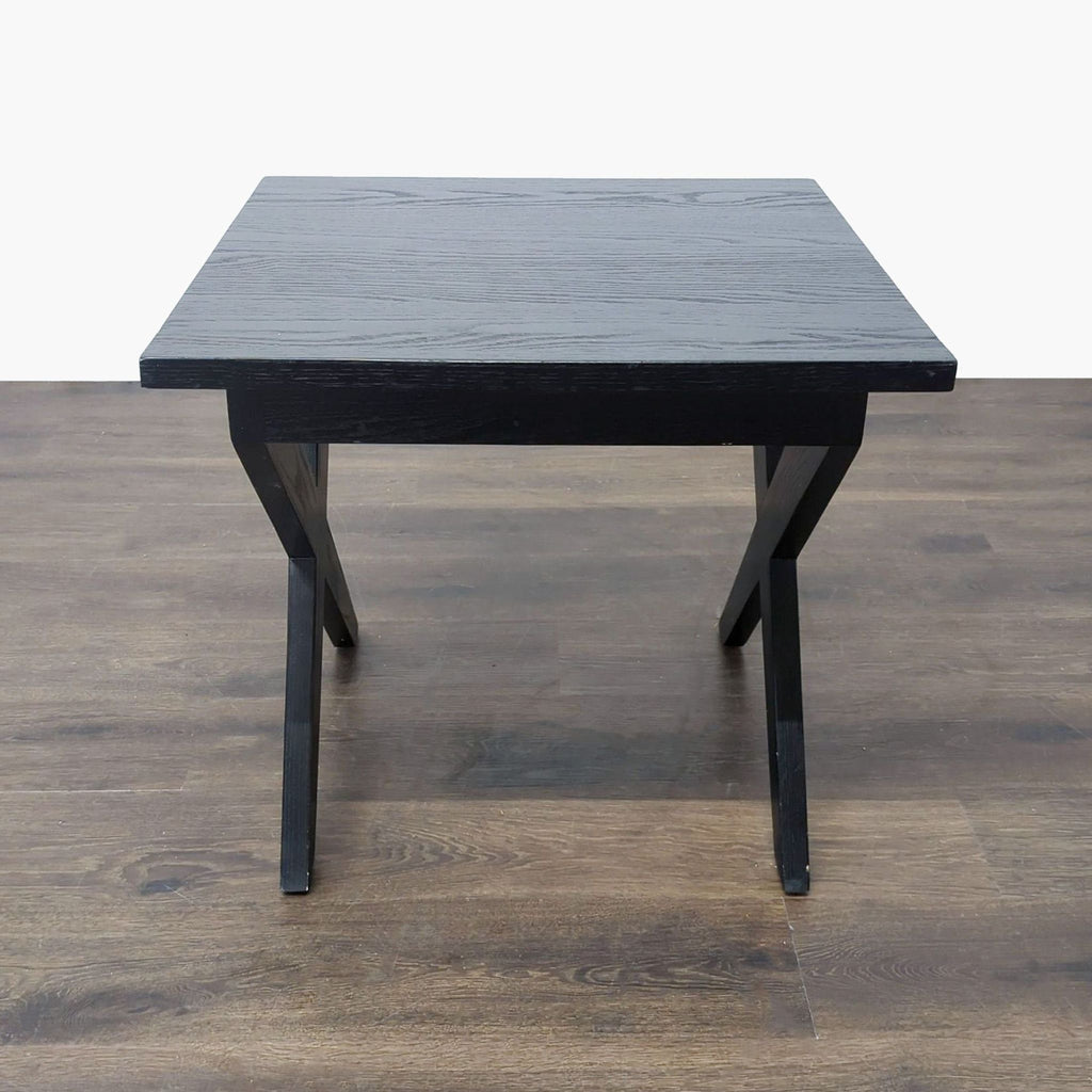 2. Front view of a modern black end table with angled legs and a slick rectangular top.