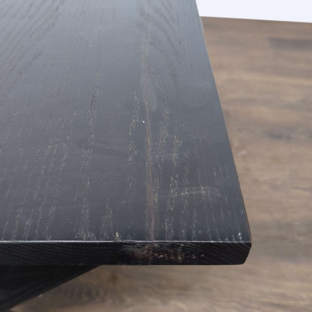 3. Close-up of the black wooden tabletop, highlighting the wood grain and smooth finish of the end table.