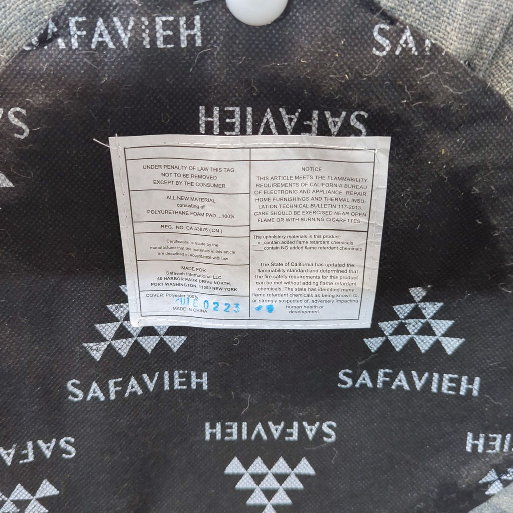 Safavieh ottoman, button tufted with fabric upholstery; one tufting button is missing.
