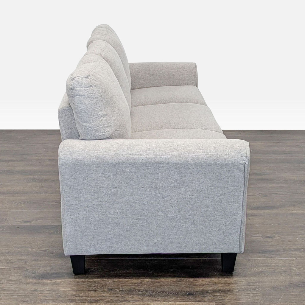 Three-seat sand sofa by Living Spaces, featuring plush cushions and classic rolled arms, ideal for comfort.