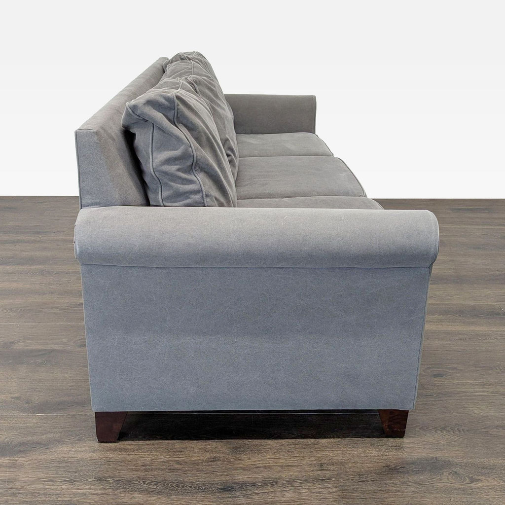 3. Profile view showing rolled arm and plush seat cushions on a gray Pottery Barn 3-seat sofa.
