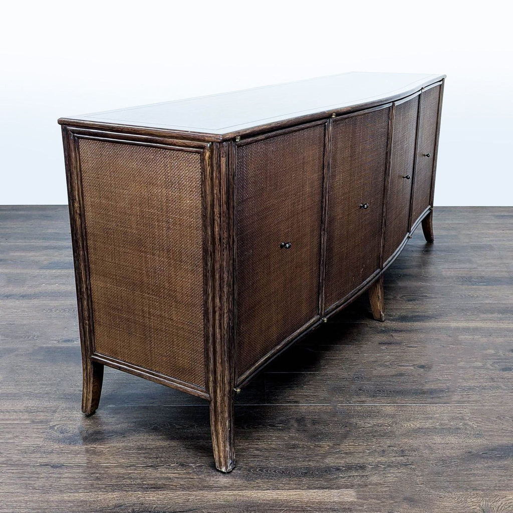 Elegant McGuire/Baker oak sideboard with curved front, raffia-clad surfaces, and rattan-trimmed, splayed-leg base.