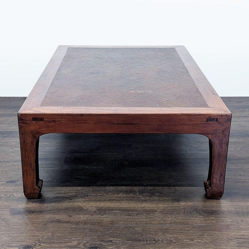 3. Coffee table with a wooden frame, woven rattan top, and curved legs, shown from the shorter end.
