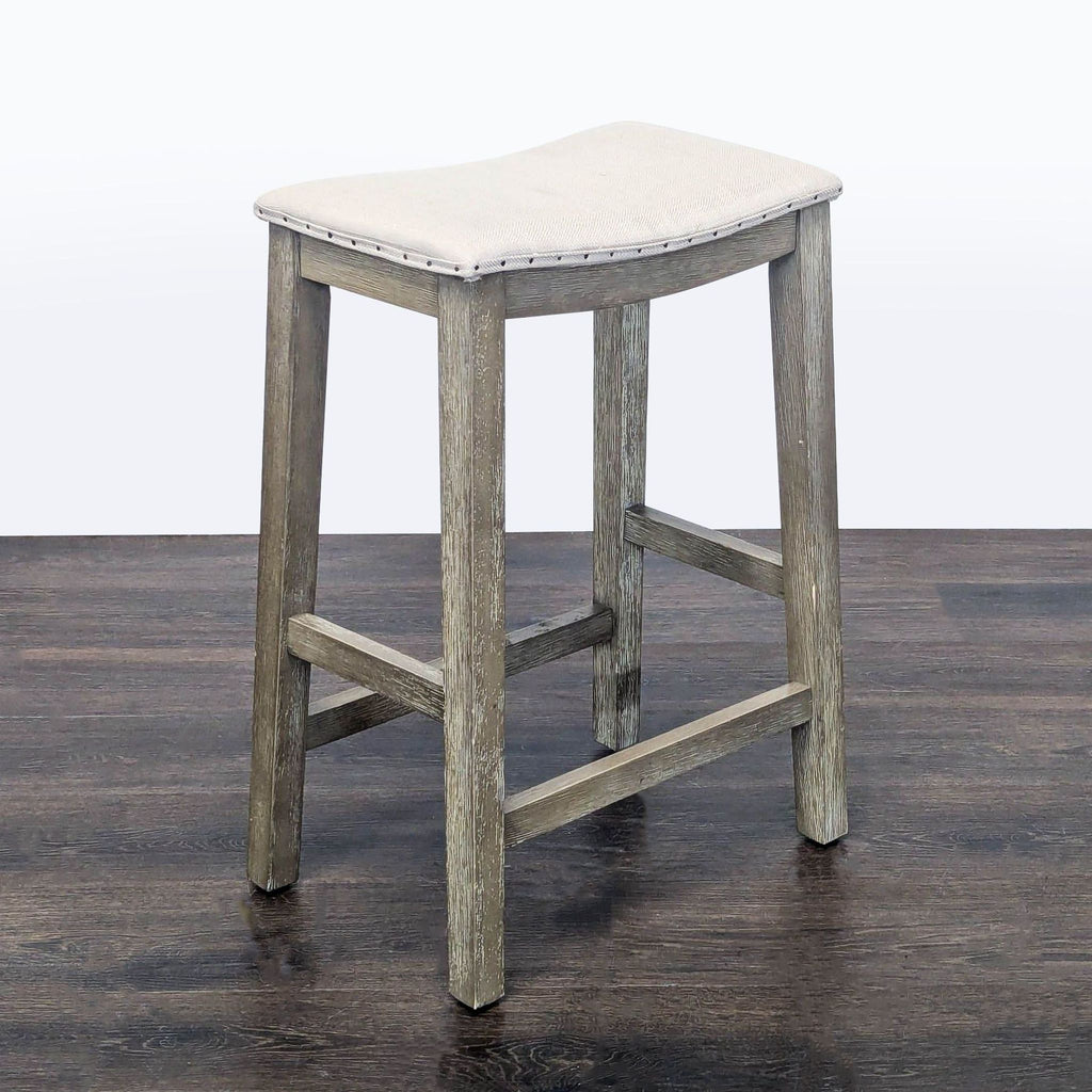 Pottery Barn stool with fabric upholstery and decorative nailhead accents, suitable for various spaces.  