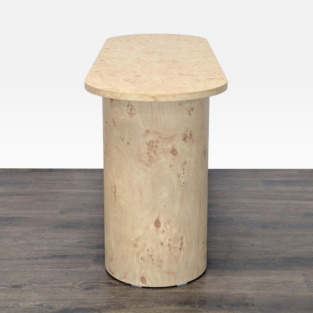 Sleek oval-shaped side table featuring a manufactured wood base wrapped in burl wood pattern paper.