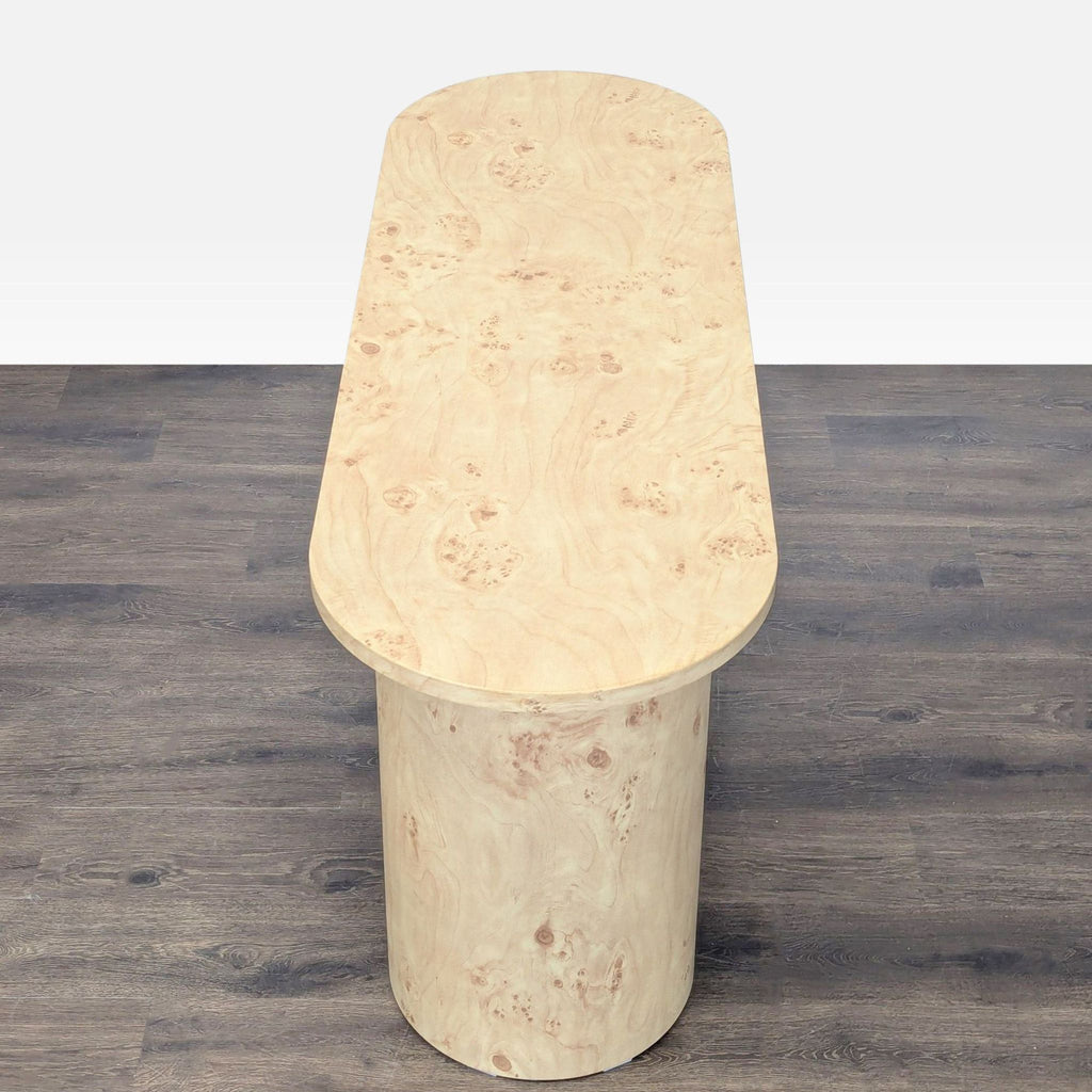 Contemporary console table with an oval silhouette and faux burl wood finish, ideal for hallway styling.