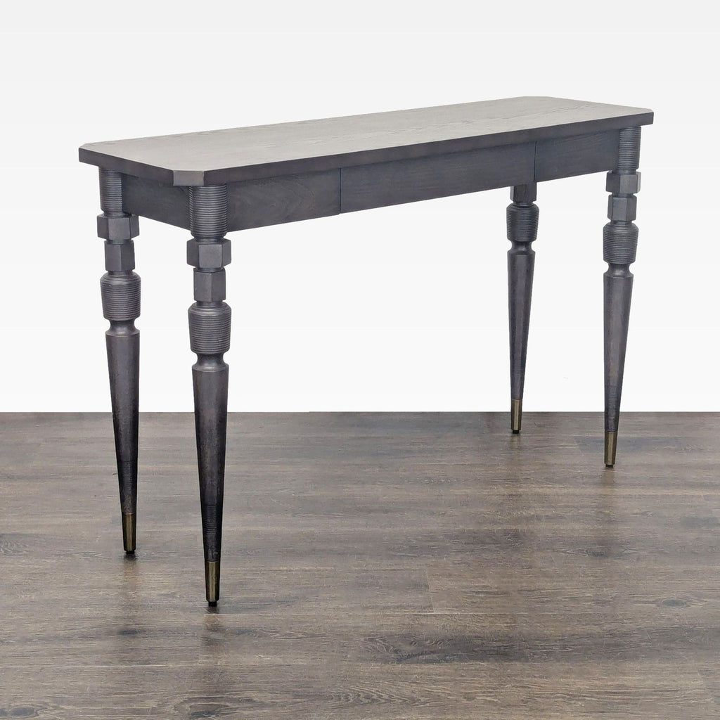 3. Sleek West Elm side table in dark finish, highlighting its tapered and textured legs with brass tips.