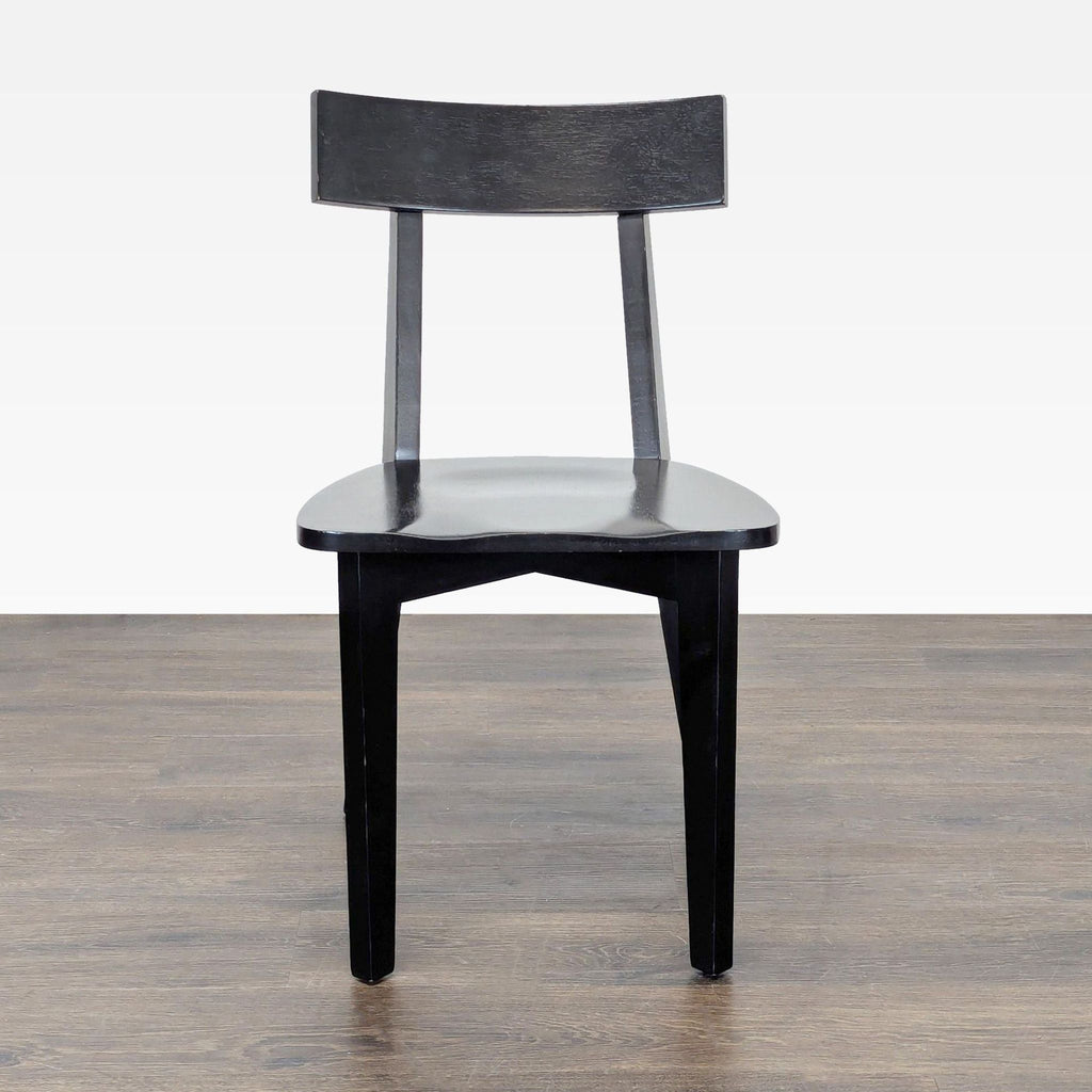 1. Black wooden dining chair with a curved backrest, viewed from the front, on a wooden floor.