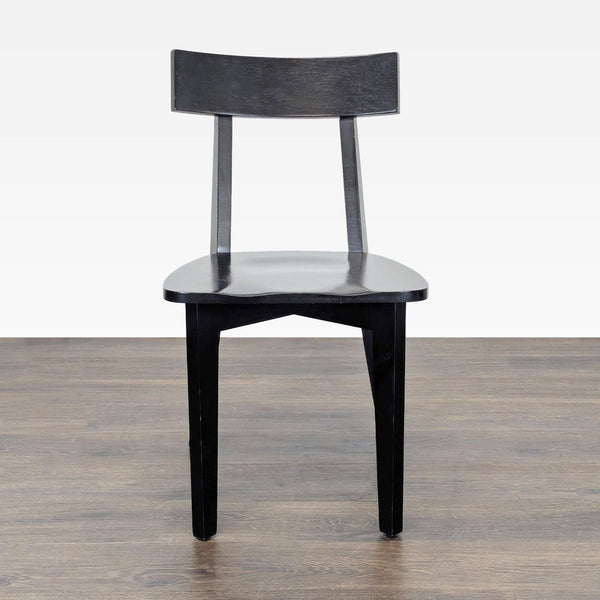 1. Black wooden dining chair with a curved backrest, viewed from the front, on a wooden floor.