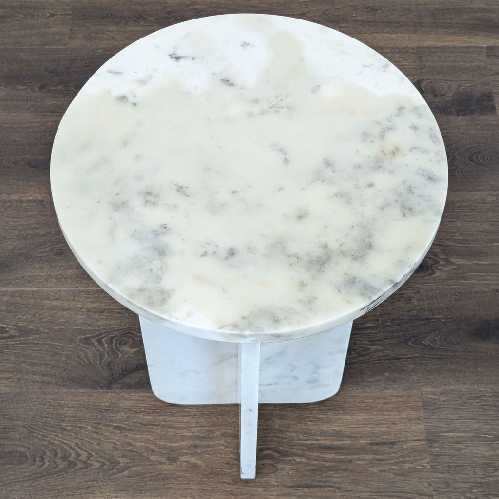2. Top view of a round marble side table, displaying light veining and soft natural patterns.  