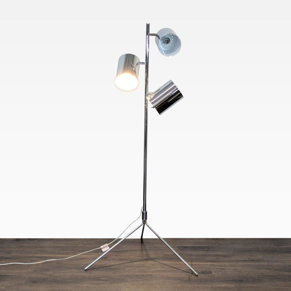 Sleek chrome tripod floor lamp with three adjustable heads for customizable lighting.