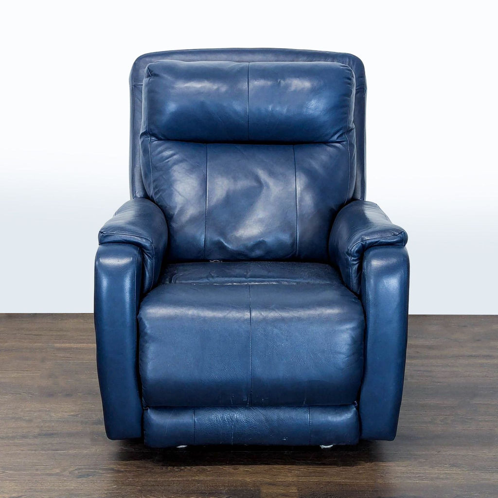 Blue leather recliner lounge chair with wide armrests and footrest, offering supportive, modern comfort.  