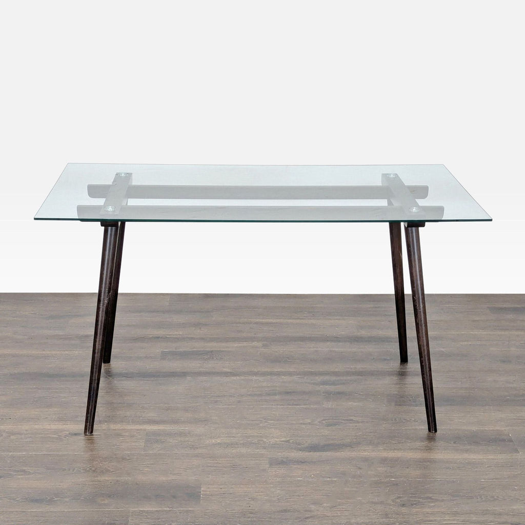 2. Modern dining table featuring a glass tabletop and dark wood frame with visible brackets at each end.