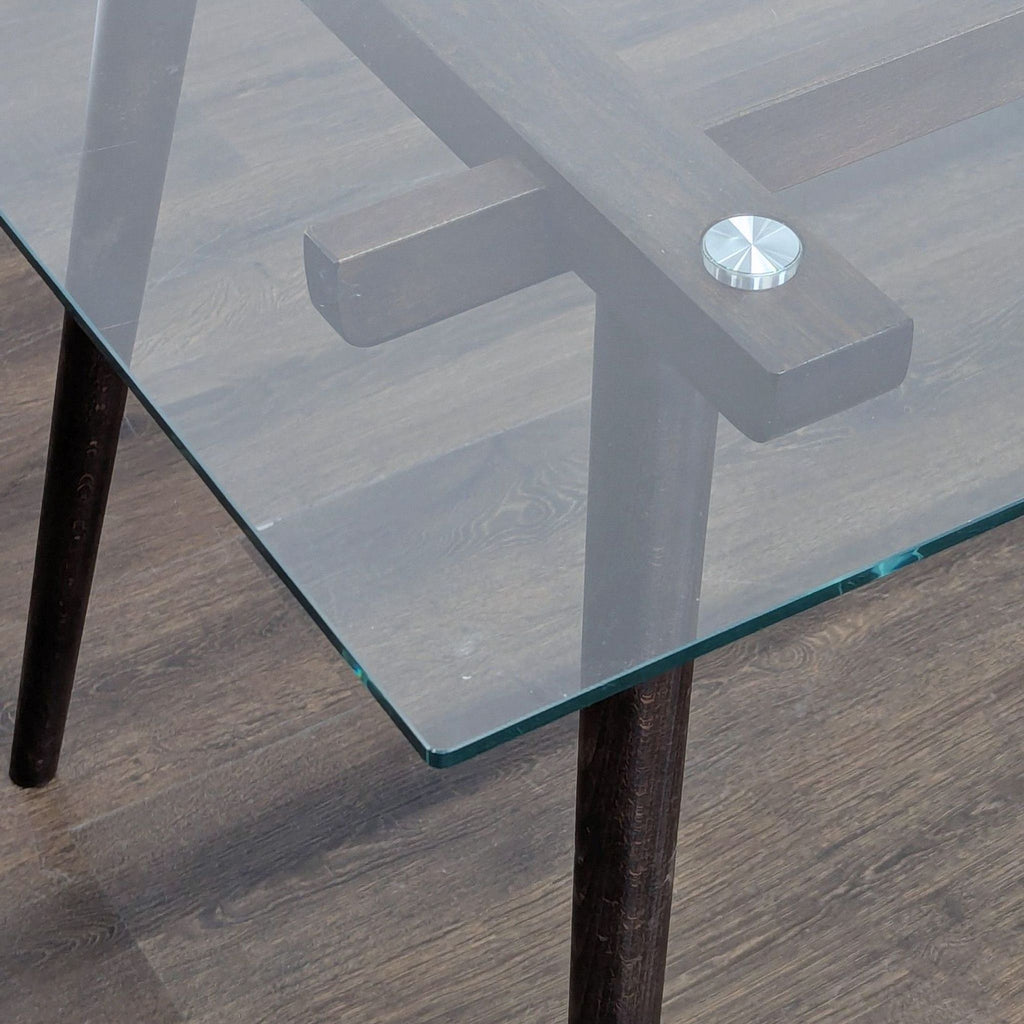 3. Close-up of dining table corner highlighting clear glass top, dark wood support, and metal fastener.