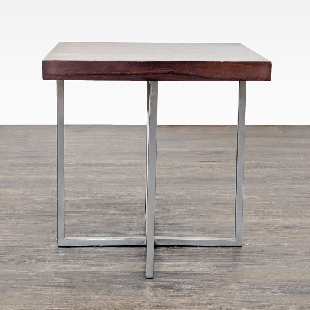 2. Square wooden end table with polished metal base, viewed from the side on a wooden floor background.  