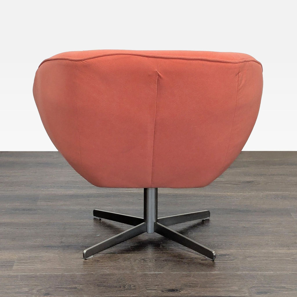 Curved, rust-hued lounge chair with sturdy metal base offers comfort and sleek modern style for lounging or reading.