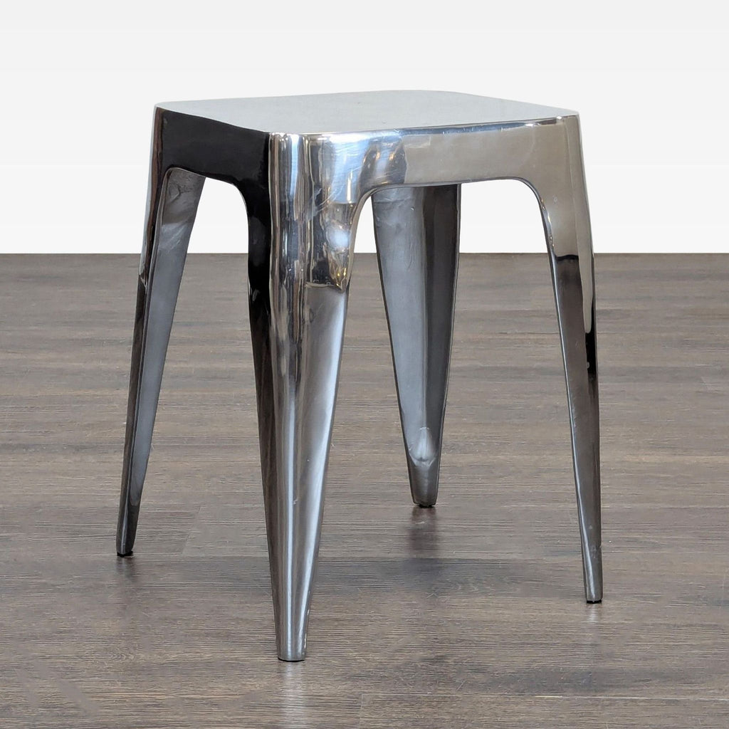1. Shiny metal side table with a square top and tapered legs, placed on a wooden floor.