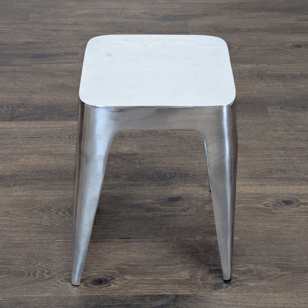 2. Top-down view of a sleek, metallic side table with curved edges and clean, minimalist lines.