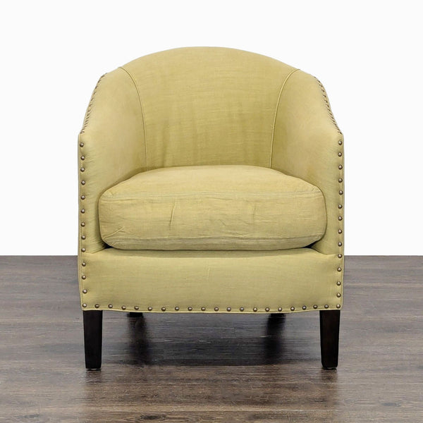 Cisco Brothers lounge chair with green upholstery, nailhead trim, and dark wood legs for a stylish lounge.