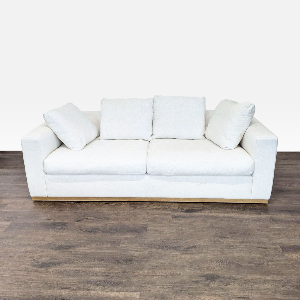 Front view of a West Elm 3-seat cream sofa with deep cushions and wide arms, showing minor seat wear.  